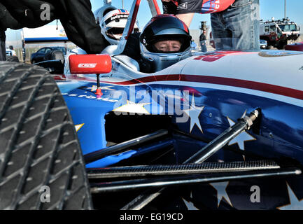 Mario Andretti, wartet legendären vier Mal Sieger des Indianapolis 500 Rennens, während seine Crew Demo-Fahrt Gewinner Air Force Staff Sgt Jayson Escalera von der 39. Logistik Bereitschaft Squadron, 19. Januar 2011, auf der Incirlik Air Base, Türkei sichert. Mehr als 30 Personen wurden ausgewählt, um in das Indy 500-Rennen-Auto fahren. Die Indy 500 Centennial Tour, koordiniert von Moral Unterhaltung Stiftung und Armed Forces Entertainment in Verbindung mit der IZOD-Indy-Car-Serie und dem Indianapolis Motor Speedway ist eine 10-tägige Moral-Reise nach Europa und dem Nahen Osten mit dem Ziel der Steigerung der Moral von mehr als Stockfoto