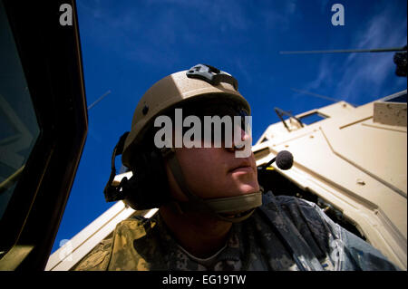 US Air Force Airman 1st Class Brandon Shamhart, ein Tactical Air Control Party Radio Operator Wartung und Fahrer mit der 807. Expeditionary Air Support Operations Squadron, Forward Operating Base Lagman, hört das Geschwätz von einer c-130 Hercules Flugpersonal über sein Radio in eine Mine-resistente, Hinterhalt-geschützten Fahrzeug bei einer Landezone Schmutz in der afghanischen Provinz Zabul. Airman Shamhart war dort zu helfen, sicherzustellen, dass die Schmutz Landezone war sicher für eine c-130 Hercules zu landen und das Flugpersonal mit alle relevanten Informationen über Funkverbindungen. Die Besatzung war Neede liefern. Stockfoto