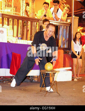 Ho Eng Hui, Kung-Fu-Meister, bricht Kokosnuss mit Zeigefinger, beliebte Show in der Jonker Street, Malacca, malaysia Stockfoto