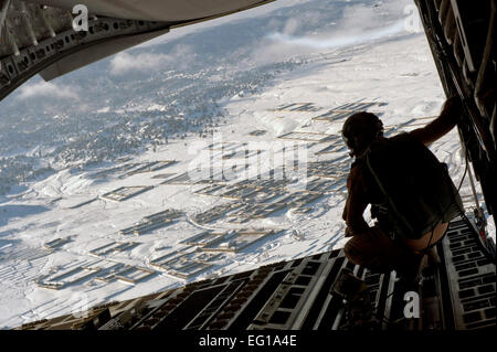 US Aor Force Staff Sgt Christopher Bankston, ein 816th Expeditionary Airlift Squadron Loadmaster Uhren als Luftfracht Lieferung von ein Frachtflugzeug der US Air Force c-17 Globemaster III über den Himmel über Afghanistan losgelassen wird. Die c-17 Aircrew Luft geliefert die Ladung, bestehend aus Kraftstoff und andere verschiedene Lieferungen zu einem entfernten vorwärts operating Base in Afghanistan. Sergeant Bankston ist ab der 7. Airlift Squadron McChord Air Force Base, Wash eingesetzt.  Master Sergeant Adrian Cadiz Stockfoto