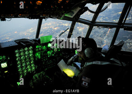 YOKOTA AIR BASE, Japan--befasst Capt Yuri Batten, 36. Airlift Squadron, sich mit einer Karte 19 März während des Fluges auf eine C - 130H Hercules voller medizinische Versorgung. Die medizinische Versorgung flogen nach Sendai und Hanamaki Flughafen verteilten lokalen Krankenhäusern und Evakuierung Zentren im Rahmen der Operation Tomodachi. Staff Sgt Jonathan Steffen Stockfoto