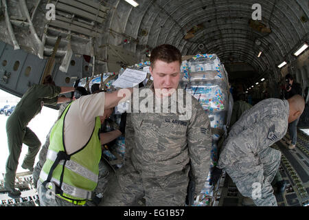 YOKOTA AIR BASE, Japan--schiebt Senior Airman Nicholas Abbott Zentrum, 730. Air Mobility Squadron, eine Palette mit Wasserflaschen auf einer c-17-Globalmaster-III hier März 20. Die Palette war Bestandteil der der ersten humanitären Hilfsgüter nach Sendai geliefert werden. Osakabe YasuoReleased Stockfoto