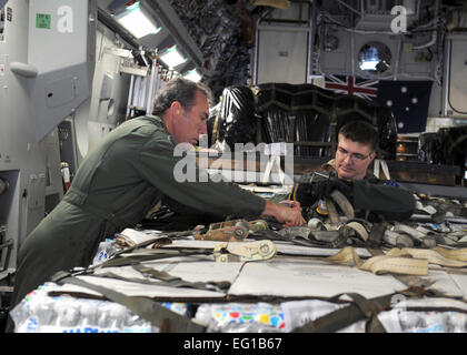 YOKOTA AIR BASE, Japan--Warrant Officer Ray Maconachie links und Sergeant Chris Voight ziehen Sie Paletten in einer c-17 Globemaster III von der Royal Australian Air Force Base Amberley März 21. Mit Hilfe der Yokota Flieger lieferte die RAAF 16 Paletten der humanitären Hilfe nach Sendai, Japan, zur Unterstützung der Operation Tomodachi. Hier sollen die beiden zusammenarbeiten von der RAAF 36. Squadron unterstützen Hilfsaktionen werden durchgeführt, um die Unterstützung der betroffenen durch die Zerstörungen durch das Erdbeben und den Tsunami März 11. Senior Airman Michael J. Veloz Stockfoto