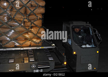 Ein japanischer Arbeiter in Misushima, Japan, treibt einen k-Loader mit einer Palette mit humanitären Hilfsgütern 23. März 2011. Mitglieder aus der 36. Airlift Squadron und der 374th Logistik Bereitschaft Squadron transportiert 15.000 Pfund der Lieferungen von Chitose Air Base, Japan Mitsushima nach Japan.  Staff Sgt Robin Stanchak Stockfoto