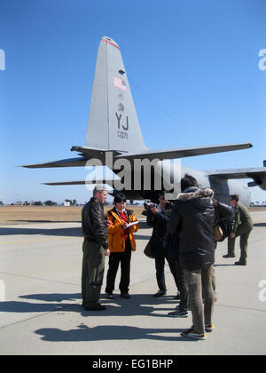 Vertreter der japanischen Medien interview Major Rob Mitchell, ein 36. Airlift Squadron als Pilot auf der Yokota Air Base, Japan, nach einem Flug nach Sendai Airport am 24. März 2011. 36. AS geliefert 2.378 Gallonen Dieselkraftstoff an Bord eine US Luftwaffe C - 130H Hercules-Transportflugzeuge auf Ersuchen der Regierung von Japan. Stockfoto