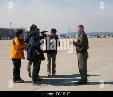 Vertreter der japanischen Medien interview Major Rob Mitchell, ein 36. Airlift Squadron als Pilot auf der Yokota Air Base, Japan, nach einem Flug nach Sendai Airport am 24. März 2011. 36. AS geliefert 2.378 Gallonen Dieselkraftstoff an Bord eine US Luftwaffe C - 130H Hercules-Transportflugzeuge auf Ersuchen der Regierung von Japan. Stockfoto