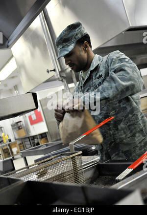 YOKOTA AIR BASE, Japan--bereitet Staff Sgt Justin Reynolds, 374th Kraft Support Squadron Esszimmer Einrichtung Schichtleiter, sich auf einen Stapel von Pommes frites hier 24 März kochen. Dayton, Ohio Native ist geänderte Arbeitszeiten um Mahlzeiten alle autorisierten Yokota TDY Mitglieder und Unterstützung bei der Operation Tomodachi anbieten zu können. Flieger 1. Klasse Andrea Salazar Stockfoto