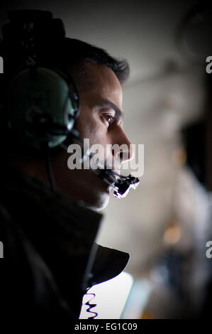 ÜBER JAPAN--Schaut Chief Master Sgt. Benjamin Caro Jr., 374th Airlift Wing Command Chief Master Sergeant, aus dem Fenster einer C - 130H Herkules bei der Zerstörung noch vorhanden am Flughafen Sendai, Japan, 26. März 2011. Chief Caro flog mit Oberst Otto Feather, 374th AW Kommandanten, fünf Paletten von Trinkwasser für japanische Bürger in Not nach Sendai Airport fliegen. Staff Sgt Samuel Morse Stockfoto