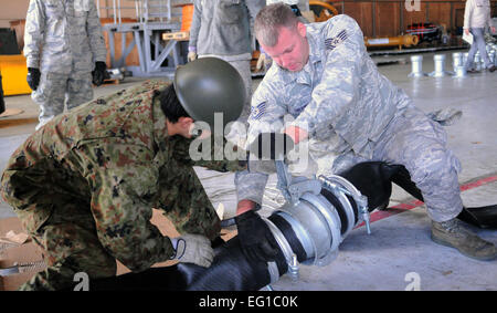 YOKOTA AIR BASE, Japan--techn. Sgt John Obermuller, 374th Wartung Geschwader und Mitglied Japan Ground Self-Defense Force arbeiten an einem Schlauch vor dem Transport nach Fukushima, hier März 26. Die Wasserpumpen werden verwendet, um das Kraftwerk in Fukushima zu kühlen. Airman 1st Class Krystal M. Garrett Stockfoto