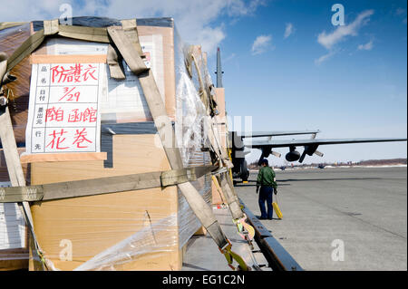 CHITOSE AIR BASE, Japan--ein K-Loader voller Paletten sitzt ein 36. Airlift Squadron c-130 auf Chitose Luftwaffenstützpunkt 29 März laden bereit. Der c-130 ist humanitärer Güter und Zubehör für die japanischen Streitkräfte zur Unterstützung der Operation Tomodachi bekommen. /Master Sgt Jeromy K. Cross Stockfoto