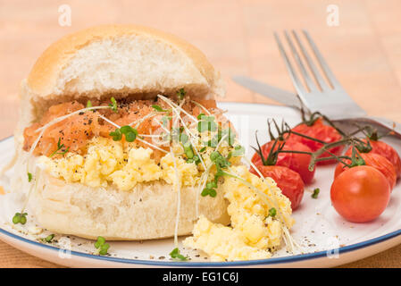 Ein Räucherlachs und Rührei Brot Roll Frühstück mit einigen gegrillte strauchtomaten - geringe Schärfentiefe Stockfoto