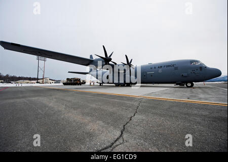 GEMEINSAME Basis ELMENDORF-RICHARDSON, Alaska – C-130J Hercules, von 19. Airlift Wing, Little Rock Air Force Base, Arkansas sitzt auf dem Flug Linie hier April 4, Mitglieder der 732. Air Mobility Squadron Laden einer 32-Fuß-Plattform, bestehend aus einem Humvee und Haubitze in der Rückseite es. Dies war in der Vorbereitung für eine schwere und Personal mit dem 3. Bataillon, 377. Parachute Field Artillery Regiment durchgeführt.  Senior Airman Christopher Gross Stockfoto