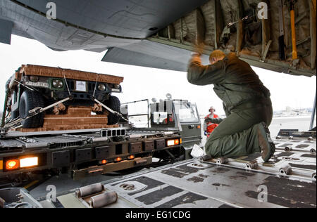 GEMEINSAME Basis ELMENDORF-RICHARDSON, Alaska-techn. Sgt Dave Gabe, 41. Airlift Squadron signalisiert Senior Airman Brandon Smith, 732. Air Mobility Squadron, die 32-Fuß-Plattform, bestehend aus einem Humvee und Haubitze, bewegen zu übermitteln. Mitglieder des 732. AMS geladen die Plattform auf die Rückseite einer c-130 April 4.   Das c-130 J Modell wurde aus der 19. Airlift Wing, Little Rock Air Force Base, Arkansas. Dies war in der Vorbereitung für eine schwere und Personal mit 43. Bataillon, 377. Parachute Field Artillery Regiment durchgeführt.  Senior Airman Christopher Gross Stockfoto