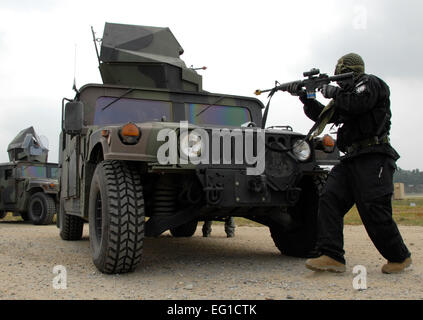 Opposition zwingt OPFOR Mitglied Airman 1st Class Destry Swadowski, ein Notfallmanagement-Techniker zugewiesen zum 51. Bauingenieur-Geschwader, Osan Air Base, Republik Korea, feuert Rohlinge aus dem m-4 Gewehr gegen einen Konvoi von Humvees 22. Juni 2011. Rund 150 Flieger aus der 51. Bauingenieur-Geschwader beteiligte sich an Prime BEEF Training.  Senior Master Sergeant Paul Holcomb Stockfoto