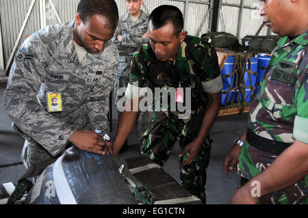 US Air Force Airman 1st Class Brandon Jenkins, ein Ausleger mit 374th Logistik Bereitschaft Squadron Bekämpfung Mobilität Flug, arbeitet mit einem indonesischen Luftwaffe Rigger, ein Low-Cost-, niedriger Höhe LCLA Bündel während einer Unterrichtsstunde Takelage Übung bewältigen West 11 auf Halim Air Base, Indonesien, 22. Juni 2011 zu bauen. Die Fracht Takelage Lektion war völlig Hands-on mit USA und indonesischen Rigger arbeiten Side-by-Side, ein LCLA bauen zu bündeln, das ist eine neuere Art von Paletten, die häufig von US-Streitkräften verwendet, um Lieferungen schnell und effizient airdrop.  Captain Raymond Geoffroy Stockfoto