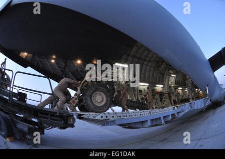 Flieger aus der 455. Expeditionary Luft Port Squadron arbeiten Seite an Seite mit zusammenarbeiten, eine c-17 Globemaster III mit Ladung hier 1. August 2011 laden. Die 455 EAPS Mission bewegt sich Passagiere und Fracht in Afghanistan. Mehr als 80 Prozent aller Menschen und Lieferungen durch das Land reisen kommen durch 455 EAPS. Stockfoto