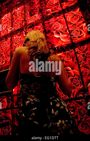 Kellnerin in geblümten Kleid nimmt Tischreservierungen von floralen Mauer an der beliebten Wolfgang Puck Bar & Grill, MGM Grand, Las Vegas Stockfoto