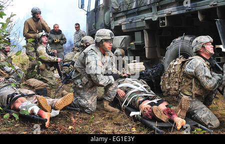 Pararescuemen von der 212th Rescue Squadron und Mitgliedern des Baker Company, 3rd Platoon, 509. Infanterie RegimentAirborne suchen Sie nach der HH - 60G Pavehawk Hubschrauber während des Trainings auf der gemeinsamen Basis Elmendorf-Richardson 21. September 2011.  Die Ausbildung konzentriert sich auf schnell Pflege unter Feuer und gab Training auch Baker Company wie reagieren wenn Pararescuemen ankommen.  Staff Sgt Zachary Wolf Stockfoto