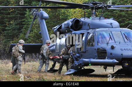 Pararescuemen von der 212th Rescue Squadron und Mitgliedern des Baker Company, 3rd Platoon, 509. Infanterie Regiment Airborne, laden einen Unfall in einem HH - 60G Pavehawk Hubschrauber während des Trainings auf der gemeinsamen Basis Elmendorf-Richardson 21. September 2011.  Die Ausbildung konzentriert sich auf schnell Pflege unter Feuer und gab Training auch Baker Company wie reagieren wenn Pararescuemen ankommen.  Staff Sgt Zachary Wolf Stockfoto