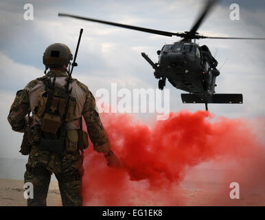 US Air Force major Matthew McGuinness erscheint eine Fackel signalisieren eine Air Force HH - 60 G Pave Hawk-Suche und Rettung Hubschrauber wo landen 5. Dezember 2011, während der Übung zu bewältigen Engel 12 in Okinawa, Japan. Der 31. und 33. Rettung Geschwader gepaart mit Partnern aus der Japan Air Self-Defense Force während fertig zu werden Engel auf Wasser und Land Rettungs- und Triage Taktiken zu trainieren. McGuinness ist 31. Rescue Squadron Director of Operations.  Airman 1st Class Maeson L. Elleman Stockfoto