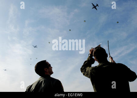 US Air Force Capt. Dereck Monnier right and 1st Lt. Tory Lodmell beobachten wie Armee-Fallschirmjäger auf dem Flugplatz während einer "Samurai Surge" Formationsflug 10. Januar 2012, auf der Yokota Air Base, Japan hinab. Die Flieger unterstützt die Mission als drop-Zone Kontrollbeamten, gewährleisten sichere Airdrop Trainingsbetrieb auf Yokota AB Flugplatz. Monnier und Lodmell sind beide c-130 Hercules-Co-Piloten mit der 36. Airlift Squadron.  Captain Raymond Geoffroy Stockfoto