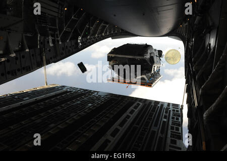 Ein Boot fliegt aus dem hinteren Teil ein Frachtflugzeug der US Air Force c-17 Globemaster III 9. April 2012, über den umgebenden Naval Base Guam während einer fünftägigen Mission zu fliegen, ausführen Abwürfe und Förderung gemeinsamer Service und internationale Bedienbarkeit im Pazifischen Ozean. Während der Mission fiel das Flugpersonal Static-Line Personal, Erdbewegungsmaschinen Plattformen Hochgeschwindigkeits-Container-Delivery-System CDS Bündel, Low Velocity CDS bündelt und Höhen-Low-Eröffnung Jumper während ihrer Zeit in Guam. Das Flugzeug wurde von der 535th Luftbrücke Geschwader auf gemeinsamer Basis Pearl Harbor Hickam eingesetzt, Stockfoto