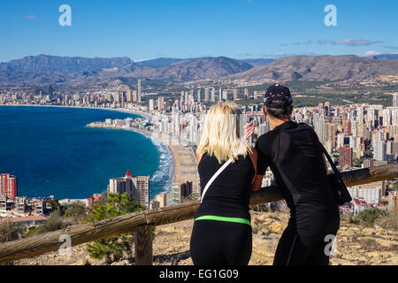 Touristen tragen sportliche Kleidung, genießen Sie den Blick von Benidorm, Costa Blanca, Spanien. Dicht hinter ihnen entnommen. Stockfoto