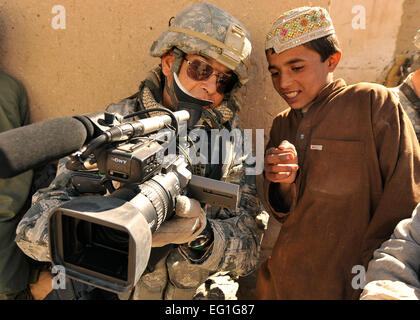 Master Sgt. Robert Carreon zeigt einer afghanische Studenten seiner Aufnahmen 7. Januar 2010, an der Basar-Schule in Hutal, Afghanistan. Carreon ist ein Videofilmer mit 4. Bekämpfung der Kamera und war die 5. Brigade, 2. US-Infanteriedivision an.  Staff Sgt. Dayton Mitchell Stockfoto