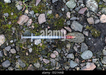 Injektionsspritzen durch eine injizierenden Drogenkonsumenten in einer vernachlässigten Edinburgh Friedhof verworfen. Schottland, Großbritannien. Stockfoto