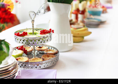 verschiedene Desserts serviert mit Obst auf einem Tablett Stockfoto