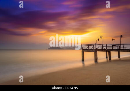 Langzeitbelichtung der magischen unwirklich bunt Sonnenaufgang und Anlegestelle, Stadtstrand von Nha Trang, Vietnam Stockfoto