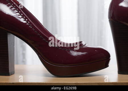 Verschiedene Schuhe auf Holzregalen. Stockfoto