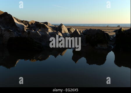 geformt durch das Meer, reflektieren die Gower natürlichen Felsformationen in einer rockpool Stockfoto