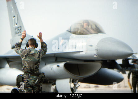 Ein Boden-Crew-Mitglied signalisiert dem Piloten eine 614 taktische Kämpfer-Geschwader F - 16C Fighting Falcon Flugzeuge als es Start auf dem ersten Tageslicht-Streik gegen irakische Ziele während der Operation Desert Storm bereitet. Stockfoto