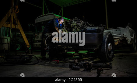 Senior Airman Christopher Moore entfernt den Motor eines LKW 18. Juli 2014, an einem unbekannten Ort im Südwesten Asien. Moore, ein Fahrzeug-Mechaniker mit 386th Expeditionary Logistik Bereitschaft Squadron wird vom 86. Fahrzeug Bereitschaft Squadron, Ramstein Air Base, Deutschland zur Unterstützung der Operation Enduring Freedom eingesetzt.  Staff Sgt Jeremy Bowcock Stockfoto