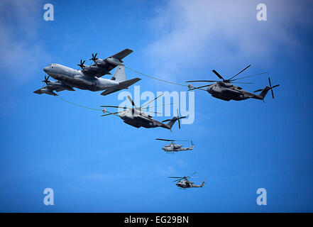 US Marine Corps c-130 links tankt zwei CH-53E Super Stallion-Hubschrauber unter den Blicken der beiden AH-1 Cobra unteren während der 2012 Kaneohe Bay Air Show auf der Marine Corps Air Station, Kaneohe Bay auf Hawaii, 28. September 2012. Stockfoto