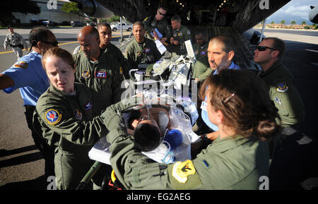 Mitglieder des 18. Aeromedical Evakuierung-Geschwader det 1 und 13. Luftwaffe Surgeon General Office transportieren ein todkranken Patienten aus dem hinteren einer c-17 Globemaster III 22. Mai 2011, am gemeinsamen Basis Pearl Harbor-Hickam, Hawaii. Der Patient wurde aeromedically von Lyndon B. Johnson Tropical Medical Center in Pago Pago, Amerikanisch-Samoa, evakuiert, nachdem er im Anschluss an einen Anfall abgesaugt, die ihn völlig abhängig von einem Ventilator zum Atmen gelassen. In Hawaii angekommen, wurde der Patient Tripler Army Medical Center, Hawaii übertragen.  Senior Airman Lauren Main Stockfoto