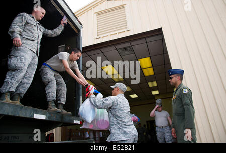 Senior Airman Walter Bolles, einem fliegenden Flug Spezialist mit der 552nd Operations Support Squadron, Tinker Air Force Base in Oklahoma, Pässe gespendete Hilfsgüter, Senior Airman John Sloop von 32. Bekämpfung Kommunikation Geschwader 23. Mai 2013. Die gespendeten Versorgungsmaterialien wurden eingeflogen von Davis-Monthan AFB, ARIZ., nachdem ein Tornado mit Windgeschwindigkeiten von 200 bis 210 km/h Moore, Oklahoma, 20. Mai 2013 getroffen. Bolles stammt ursprünglich aus Bremerton, Washington, und Sloop stammt ursprünglich aus Mooresville, NC  Techn. Sgt. Bradley C. Church Stockfoto