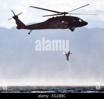 Ein Flug Medic aus Joint Task Force-Bravo 1-228. Aviation Regiment "rettet" ein Mitglied der Joint Task Force-Bravo 25. Februar 2014, aus den Wassern des Sees Yojoa, Honduras, während einer training Übung Overwater-Hebezeug. Während der Übung praktiziert Flug Sanitäter Rettung Mitglieder aus dem Wasser mit Hilfe eines Hebezeuges gesenkt von einem UH-60 Black Hawk-Hubschrauber.  Capt Zach Anderson Stockfoto