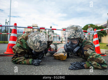 374th Medical Group Personal Low-Kraul mit einem simulierten Opfer geschnallt einen Wurf während Fähigkeit zu überleben und ATSO training 9. Oktober 2013 auf der Yokota Air Base, Japan zu betreiben. ATSO Schulungen abgehalten, der Flieger mit Grundkenntnissen in Kontingenz wieder vertraut.  Staff Sgt Chad C. Strohmeyer Stockfoto