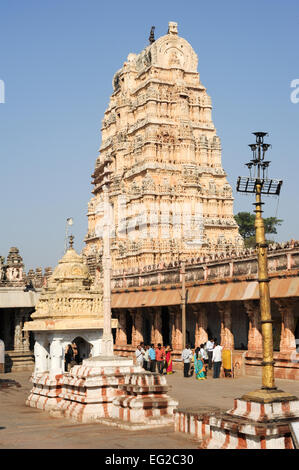 Hampi, Indien - 13. Januar 2015: Passanten vor Ansicht der Shiva-Virupaksha Tempel befindet sich in den Ruinen der antiken Stadt Stockfoto