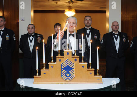 Ehemaliger Chief Master Sgt. von der Air Force Robert Gaylor zündet der Chef Kerze während der Chief Master Sergeant Anerkennung Zeremonie 9. März 2013, bei der Royal Air Force Lakenheath, England. Der Rang eines Chief Master Sergeant stellt die oberen 1 Prozent der eingetragenen Kraft. Airman 1st Class Dana J. Butler Stockfoto