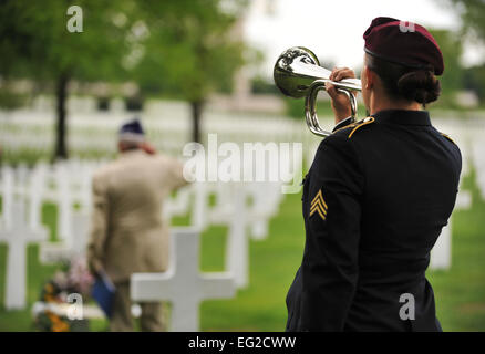 Leslie Cruise, ein Veteran des zweiten Weltkrieges, salutiert das Grab von Pvt. Richard Vargas während Armee Sgt. Jeannette Mason, 5. Quartiermeister Theatergruppe Aerial Delivery Fallschirm Rigger, spielt während einer Verlegung Kranzniederlegung am Lorraine American National Friedhof und Denkmal, St. Avold, Frankreich, 2. Juni 2014 tippt. Am 7. Juni 1944 vor siebzig Jahren Lebensretter Pvt. Richard Vargas Cruise es während der Invasion in der Normandie. Kreuzfahrt ging nach Frankreich mehrmals vor diesem Besuch auf der Suche nach seinem Freund Grab um danke zu sagen.  Senior Airman Hailey Haux Stockfoto