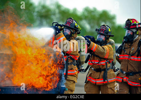 Feuerwehrleute aus der 5. Bauingenieur-Geschwader löschte ein Feuer während einer Übung 5. August 2014, auf der Minot Air Force Base, N.D. Die Bewegung konzentrierte sich auf die Fähigkeit zu reagieren, überleben und arbeiten in einem chemischen, biologischen, radiologischen und nuklearen kontaminierte Umwelt.  Senior Airman Bretagne Y. Bateman Stockfoto