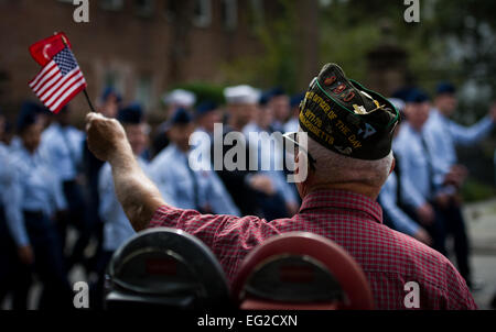 US Marine Corps Veteran Richard Starr "Wellenlinien" eine amerikanische Flagge als Mitglieder der gemeinsamen Basis Charleston Marsch von während der Teilnahme an der Ralph H. Johnson Veterans Hospital jährliche Veterans Day Parade 8. November 2014, in Charleston, S.C. Die Ursprünge der Urlaub zurück zu Präsident Woodrow Wilson, der Tag des Waffenstillstands am Ende des ersten Weltkrieges markieren verkündet. Der Waffenstillstand zwischen Deutschland und den Alliierten Nationen, die WWI endete war an diesem Tag und ein Waffenstillstand am 11. Stunde der 11. Tag des 11. Monats im Jahr 1918 in Kraft getreten.  Airman 1st Class Clayton Cupit Stockfoto