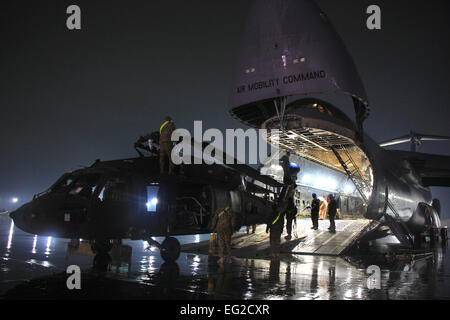 Flieger und Soldaten entlasten ein UH-60 Black Hawk aus einer c-5 Galaxy in Bagram Air Field, Afghanistan. Die c-5 diente der US Air Force seit 1969 und weiterhin wichtige schwere Luftbrücke Truppen weltweit anzubieten. US Armee-Foto / 1st Lt. Henry Chan Stockfoto