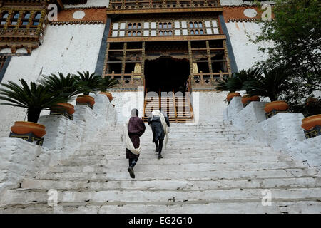 Bhutanische Männer betreten die Festung Punakha Dzong aus dem 17. Jahrhundert, auch bekannt als Pungtang Dechen Photrang Dzong, das Verwaltungszentrum des Distrikts Punakha im Punakha-Tal, Bhutan Stockfoto