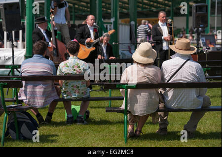 Die Besucher der Großen Yorkshire zeigen, sitzen auf den Bänken zu hören und wird von einer Gruppe von Musikern unterhalten - Tolle Yorkshire, England, UK. Stockfoto