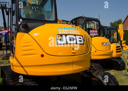 Unter blauen Himmel, in der Nähe des sauberen hellen gelben JCB 8085 Kompaktbagger auf Anzeige geparkt - Messestand, Yorkshire, England, UK. Stockfoto