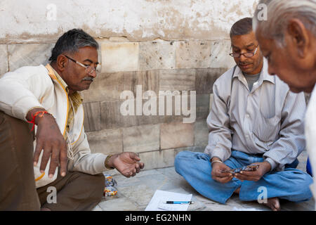 Jodhpur, Rajasthan, Indien. Die Einheimischen spielen Karten auf dem Bürgersteig Stockfoto